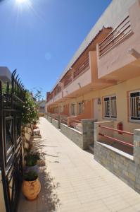 a walkway in front of a building with a fence at Zouboulia Apartments in Kardamaina