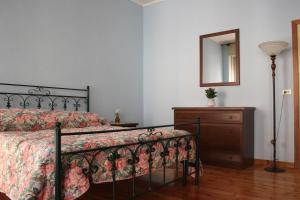 a bedroom with a bed and a dresser and a mirror at B&B Rosa Apartment in Baveno