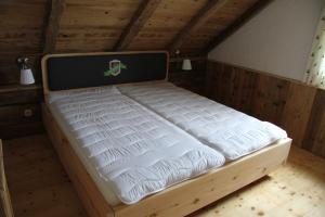 a bed in a wooden room with a laptop on it at Almchalet Feuerkogel in Ebensee
