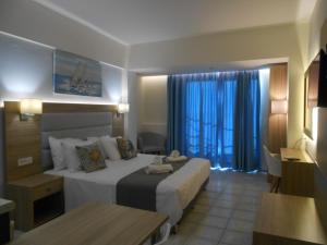 una camera d'albergo con un grande letto e un tavolo di Aristo Apts a Hersonissos