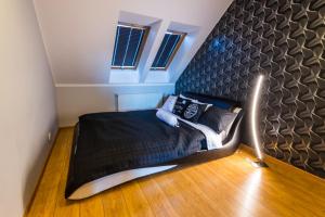 a bedroom with a bed with a black headboard at Apartament U Virusa Przy Porcie z widokiem na jezioro in Giżycko