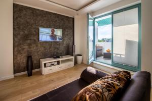 a living room with a couch and a tv at Apartament U Virusa Przy Porcie z widokiem na jezioro in Giżycko