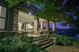 a home with stairs leading to the front yard at night at Torburnlea Homestead Luxury Accommodation in Nelspruit