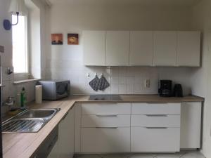 una cocina con armarios blancos y fregadero en Apartment 31 en Kassel