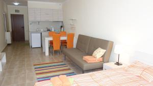a living room with a couch and a table and a kitchen at Apartments Resort BG in Primorsko
