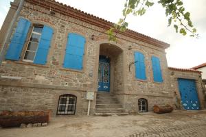 un antiguo edificio de ladrillo con ventanas y escaleras azules en TAŞKONAK, en Bergama