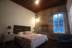 a bedroom with a bed and a brick wall at TAŞKONAK in Bergama