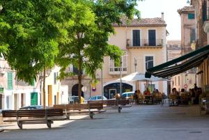 un grupo de bancos en una calle con gente sentada en mesas en POC A POC SUITES, en Palma de Mallorca