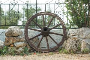 an old wooden wagon wheel in front of a fence at Summer Dream in Vlachata