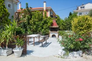 a garden with a bench and a fire place at Summer Dream in Vlachata