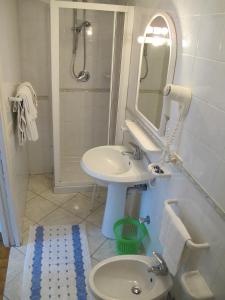 a white bathroom with a sink and a mirror at Aparthotel Villa Marinù in Ischia
