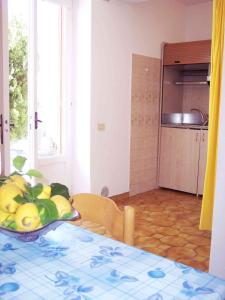 a kitchen with a table with a bowl of fruit at Aparthotel Villa Marinù in Ischia