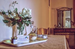 a table with a vase of flowers and a bottle of perfume at Mainades Maisonettes & Studios in Ménites