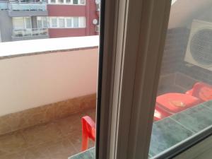 une chaise rouge assise devant une fenêtre dans l'établissement Osogovo Rooms, à Sofia