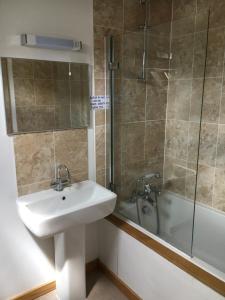 a bathroom with a sink and a shower and a tub at The Lampet Arms in Banbury