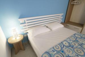 Dormitorio pequeño con cama con pared azul en Casa Dante Bed&Breakfast, en Mattinata
