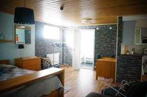 a bedroom with a brick wall and a living room at Åker Kristinagården in Skillingaryd