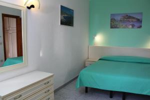 a bedroom with a bed and a mirror at Aparthotel Villa Marinù in Ischia