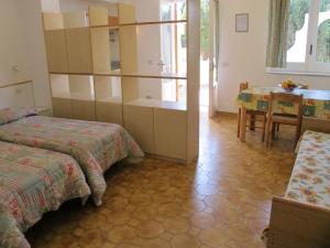 a room with two beds and a table and a dining room at Aparthotel Villa Marinù in Ischia
