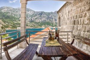 d'un balcon avec des bancs et une table sur un mur. dans l'établissement Apartments Kula, à Risan