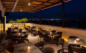 a restaurant with tables and chairs on a balcony at night at Real 1900 in Iguala de la Independencia