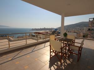 Un balcón con mesa y sillas y el mar. en Nefeli Apartments, en Sarandë