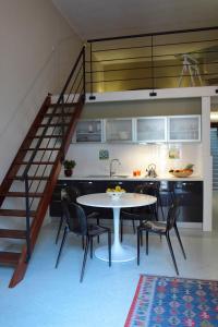 uma cozinha com uma mesa e cadeiras e uma escadaria em Palazzo Ossuna em Trapani