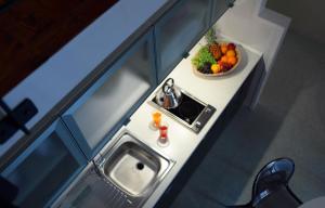 a small kitchen with a sink and a bowl of fruit at Palazzo Ossuna in Trapani