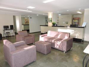 una sala de espera con 2 sillas y una mesa en Hotel Galli en Campo Grande