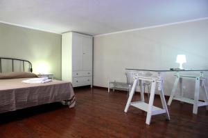 a bedroom with a bed and a table and stool at Palazzo Ossuna in Trapani +75 photos