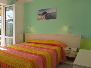a bedroom with a bed with a colorful blanket at Aparthotel Villa Marinù in Ischia