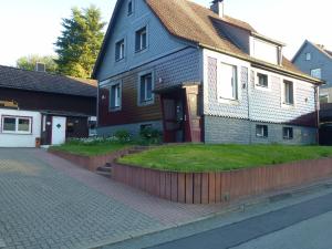 una casa con un patio de hierba delante de ella en Harzhaus Willkommen, en Braunlage