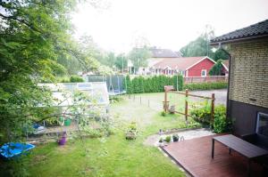 a backyard with a garden with a wooden deck at Åker Kristinagården in Skillingaryd +1 photo
