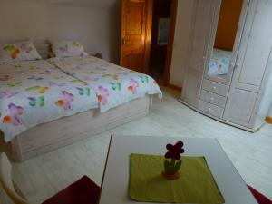 Un dormitorio con una cama y una mesa con un cactus. en Harzhaus Willkommen, en Braunlage