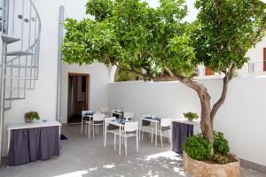 een boom op een binnenplaats met tafels en stoelen bij B&B La mia Isola in Castelluzzo
