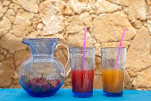 two glasses of juice and a vase on a table at B&B La mia Isola in Castelluzzo +70 photos