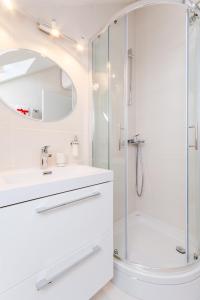 a white bathroom with a shower and a sink at Apartment Barbara in Supetar