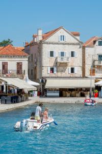 two people on a small boat in the water at Apartment Barbara in Supetar