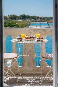 a table with two glasses of orange juice and desserts on it at Apartment Barbara in Supetar