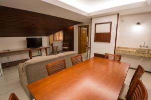 sala de estar con mesa de madera y sofá en Hotel Fioreze Origem en Gramado