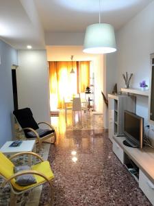 salon z żółtymi krzesłami i telewizorem w obiekcie Vittoria Colonna w mieście Vittoria