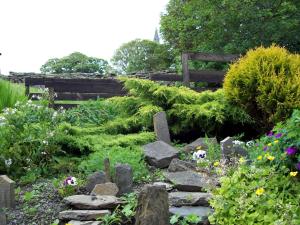 a garden with rocks and flowers and a fence at The Orkney Hotel in Kirkwall
