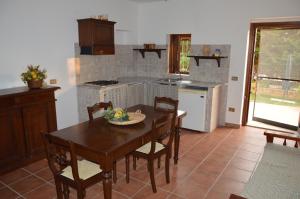 a kitchen with a wooden table and a dining room at Residence Verde Blu in Fuscaldo