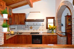 a kitchen with wooden cabinets and a stove top oven at Tenuta Santa Chiara in Palaia