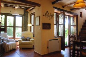 a living room with a couch and chairs and windows at Casa Africa in Mecina Fondales