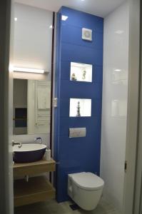 a bathroom with a blue wall and a toilet and a sink at Apartment Panorama Summerland in Mamaia