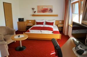 - une chambre avec un lit, un canapé et une télévision dans l'établissement Gästehaus Almrausch, Ferienanlage mit Pool, à Nassereith
