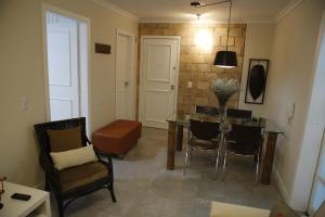 a living room with a dining room table and chairs at Apartamento central, novo e com garagem em Curitiba in Curitiba +3 photos