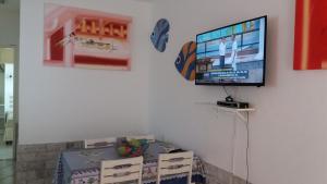 TV de pantalla plana colgada en una pared con cajas en Condomínio Elisabetta 1, en Arraial do Cabo