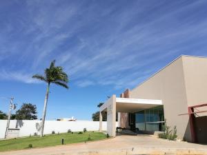 un bâtiment blanc avec un palmier en face dans l'établissement Hotel Jequitibá, à Gurupi